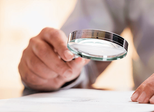 A magnifier held over a page — one of the low vision aids dispensed at the clinic